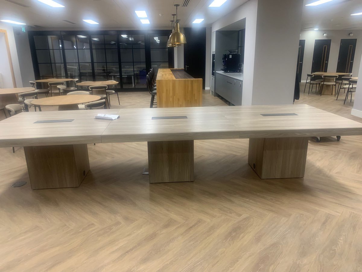 A large boardroom table assembled in a finished office break-out area