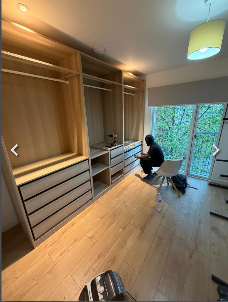 Fitted oak wardrobes and drawers built into a walk-in dressing room